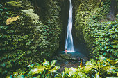 Beautiful waterfall with tropical plants . and woman traveller in Bali, Indonesia