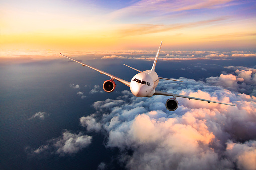 Avión comercial de pasajeros volando por encima de las nubes photo
