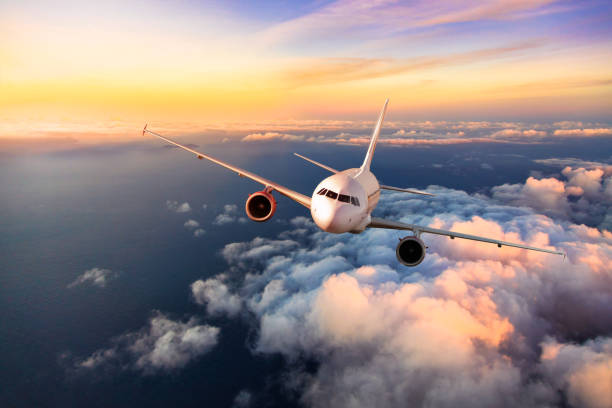 Passengers commercial airplane flying above clouds Passengers commercial airplane flying above clouds, front view. Concept of fast modern travel jets stock pictures, royalty-free photos & images