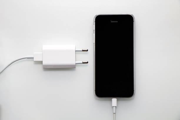 schwarz smartphone, adapter und kabel auf weißem hintergrund - usb cable cable black isolated stock-fotos und bilder