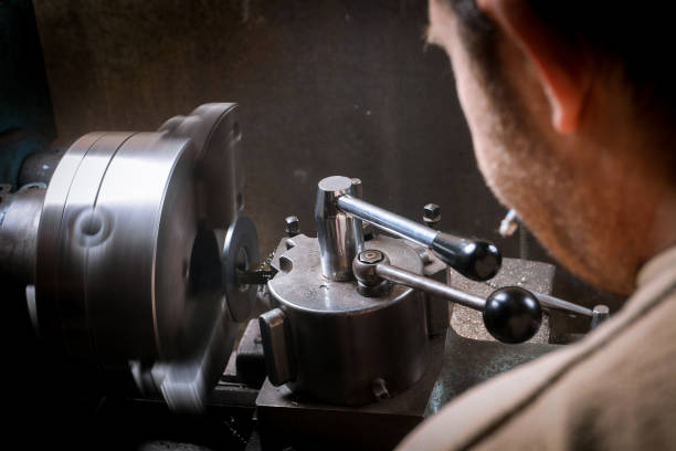 istock Metal worker shaping metal on lathe machine 955958174