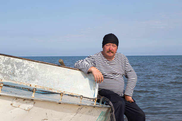Portrait of a mature man on a light dyural boat on the shore of Lake Baikal.\