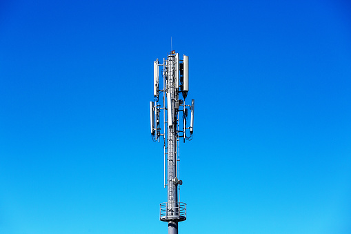 Clear blue sky provides copy space behind a cell phone mast.