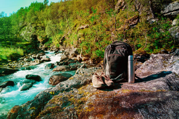 istock backpack, hiking boots and thermos in nature 955977670