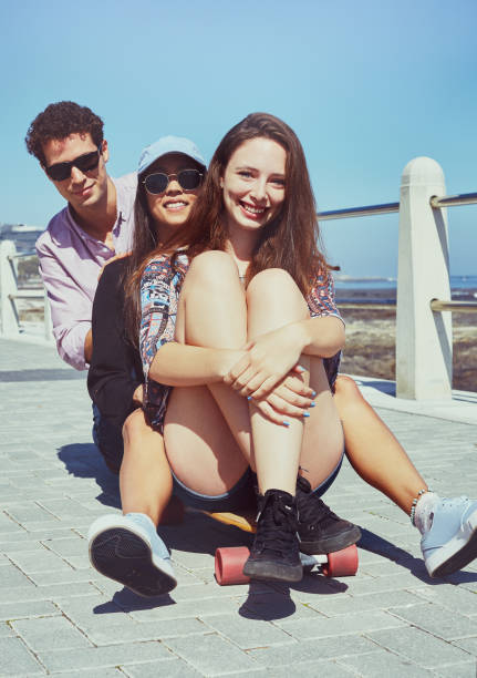 istock Three young people have fun on a skateboard by the sea 955977686