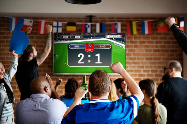 Cheerful supporters watching football at the pub