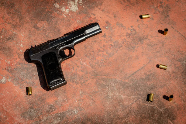 istock handgun on the concrete red backgroound 955984826