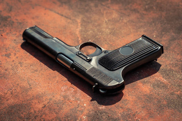 istock handgun on the concrete red backgroound 955984920