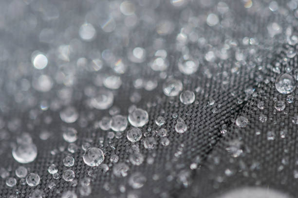 istock Closeup detailed view of raindrops on a fabric, a background. 955989732