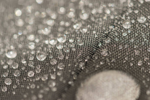 istock Closeup detailed view of raindrops on a fabric, a background. 955989874