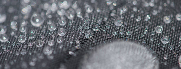 istock Closeup detailed view of raindrops on a fabric, a background. 955989920