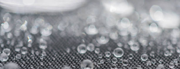istock Closeup detailed view of raindrops on a fabric, a background. 955990004