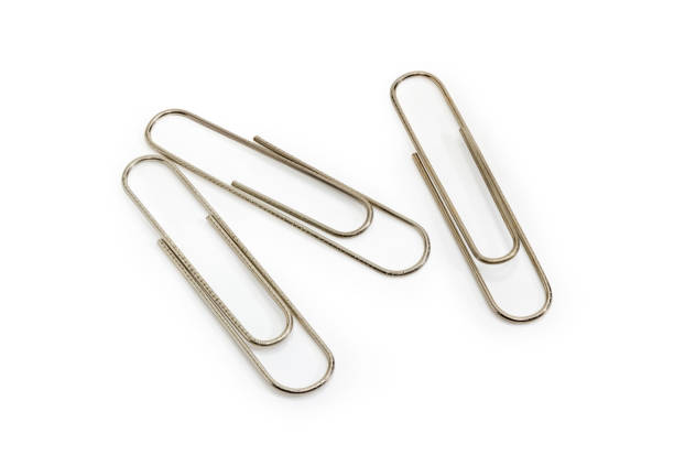 istock Three steel paper clips on a white background 955990280