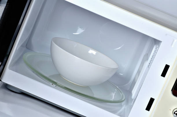 istock Inside of the microwave oven with clean empty white bowl 955990294