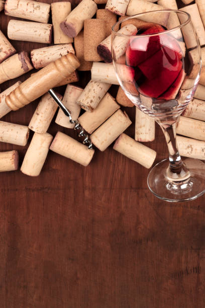 istock Glass of red wine with corks and corkscrew on a dark rustic background with copy space 955992688