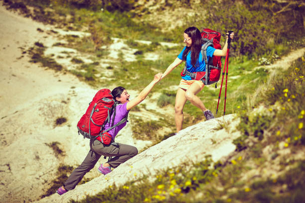 istock A helping hand, tourists helping each other. 955993844