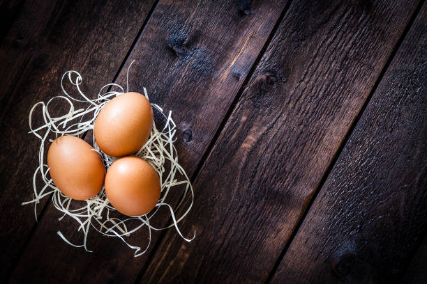 istock Three organic eggs shot from above on rustic wooden table 955994742