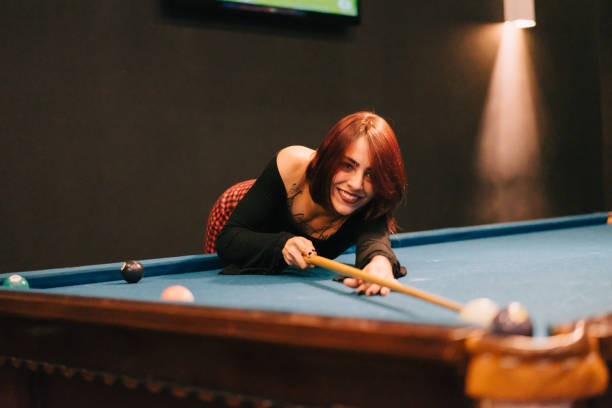 istock Beautiful tattooed woman playing billiards 955995336