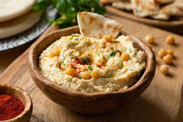 Homemade chickpea hummus bowl with pita chips and paprika stock photo