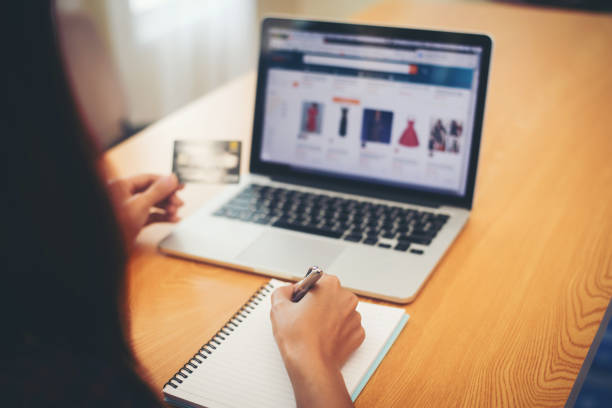 istock Young people holding credit card and using laptop computer choose some products. Online shopping concept. 956003464