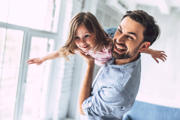 vater mit tochter zu hause - genderblend stock-fotos und bilder