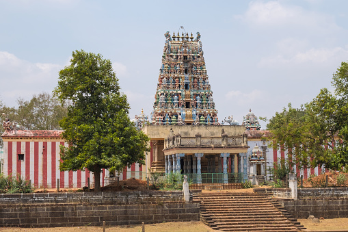 The ornate entrance gateway, or Gopuram, at the Sri Desikanathar Hindu temple in Soorakudi in Tamil Nadu state, overlooking a completely dry water tank. The temple originated in the 8th century