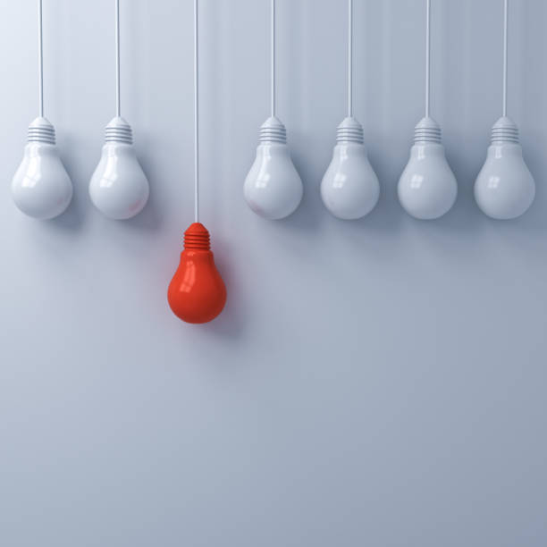 istock Think different concept , One hanging red light bulb standing out from the dim unlit white light bulbs on white wall background , leadership and individuality creative idea concepts . 3D rendering 956014678
