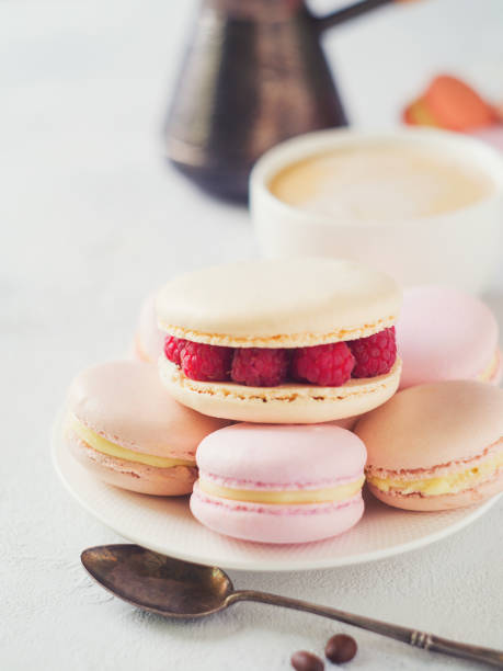 istock Macaroons and cup of coffee with flowers over white texture 956016860