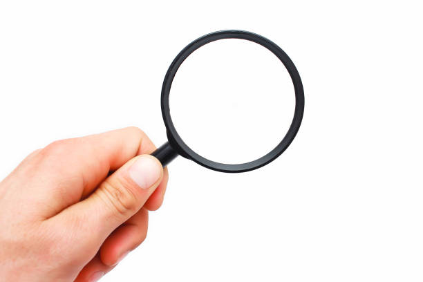 istock Male hand with a magnifying glass on a white background 956016952