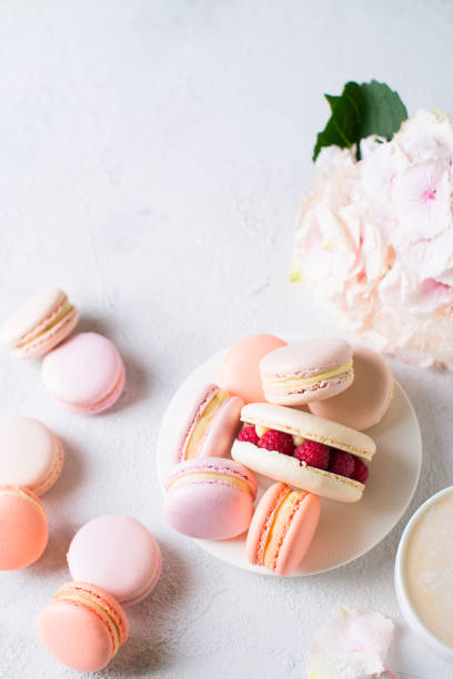 istock Macaroons and cup of coffee with flowers over white texture 956017038