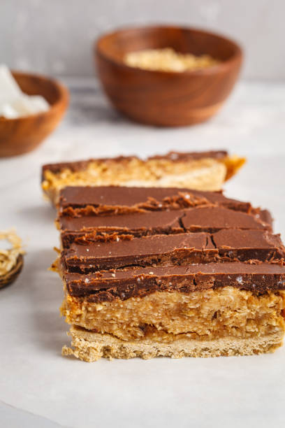 istock Coconut-oat raw vegan sliced cake with chocolate. Top view, light background, copy space. Healthy vegan food concept. 956024982