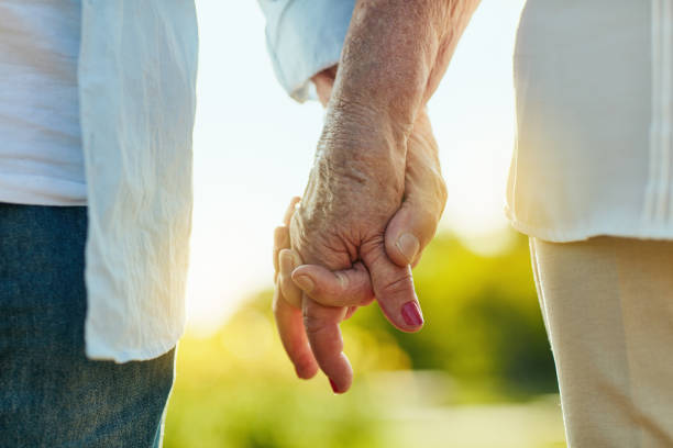 tienimi la mano e facciamola durare - holding hands couple senior couple togetherness foto e immagini stock