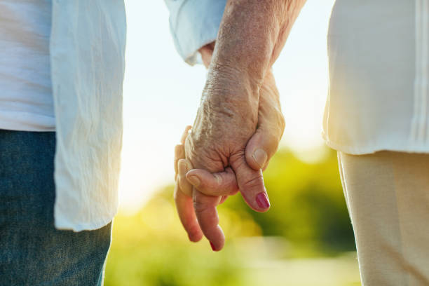 Hold my hand and let's make it last Cropped shot of a senior couple holding hands in a park falling in love photos stock pictures, royalty-free photos & images