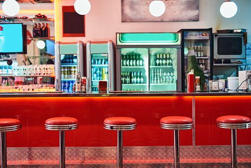 Cropped shot of bar stools in a retro diner