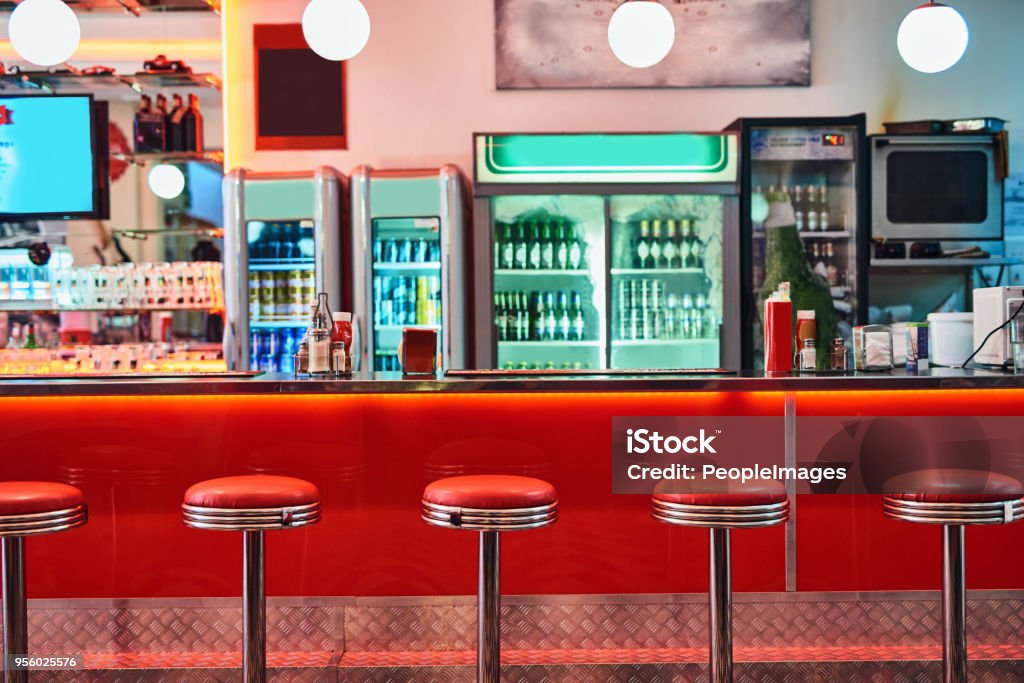 There's enough place for everyone Cropped shot of bar stools in a retro diner Diner Stock Photo