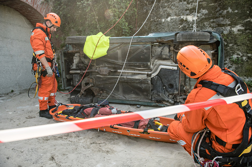 Firefighters in a rescue operation of car accident; all logos removed. Slovenia, Europe. Nikon.