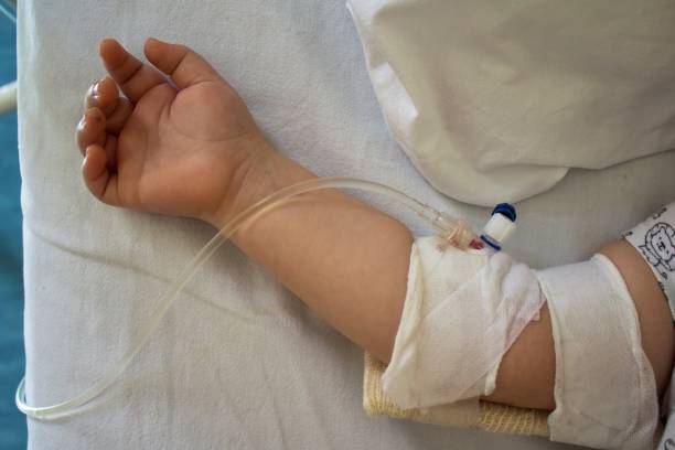 child in hospital bed with saline intravenous.little patient - infuse imagens e fotografias de stock