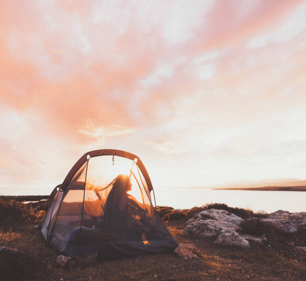 istock Woman silhouette standing in her tent 956035308