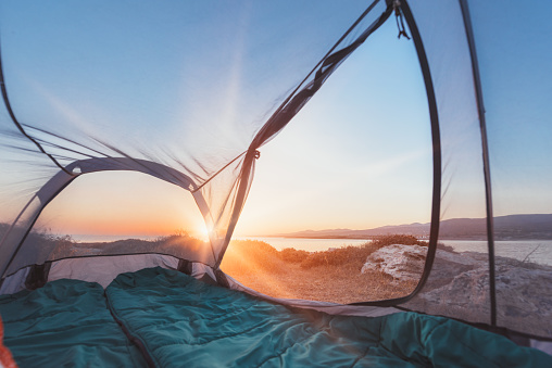 Beautiful sunrise from inside a tent on the sea coastline