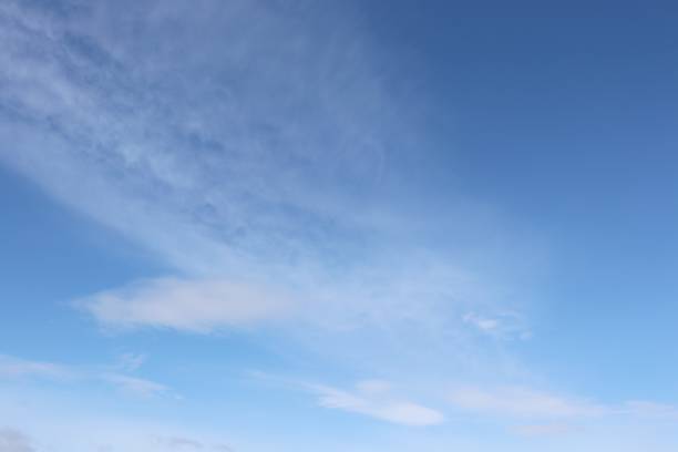 istock Close up of fluffy, wispy white clouds against blue sky 956035796