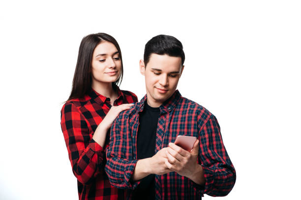 istock Woman hugs  man that looking on smartphone screen 956036316