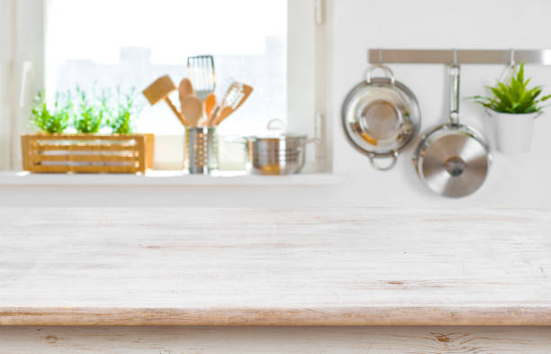 istock Copy space on wooden table top over blurred kitchen interior 956043994