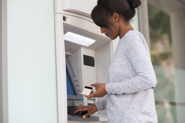 istock A woman getting money from the bank ATM machine. 956044152