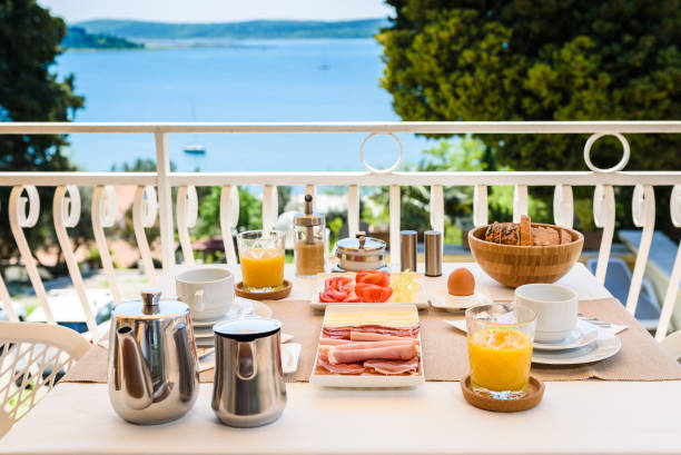 istock Continental morning breakfast table setting with sea view is served. 956044460