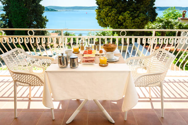 istock Continental morning breakfast table setting with sea view is served. 956044476