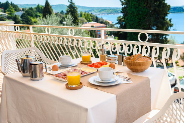istock Continental morning breakfast table setting with sea view is served. 956044504