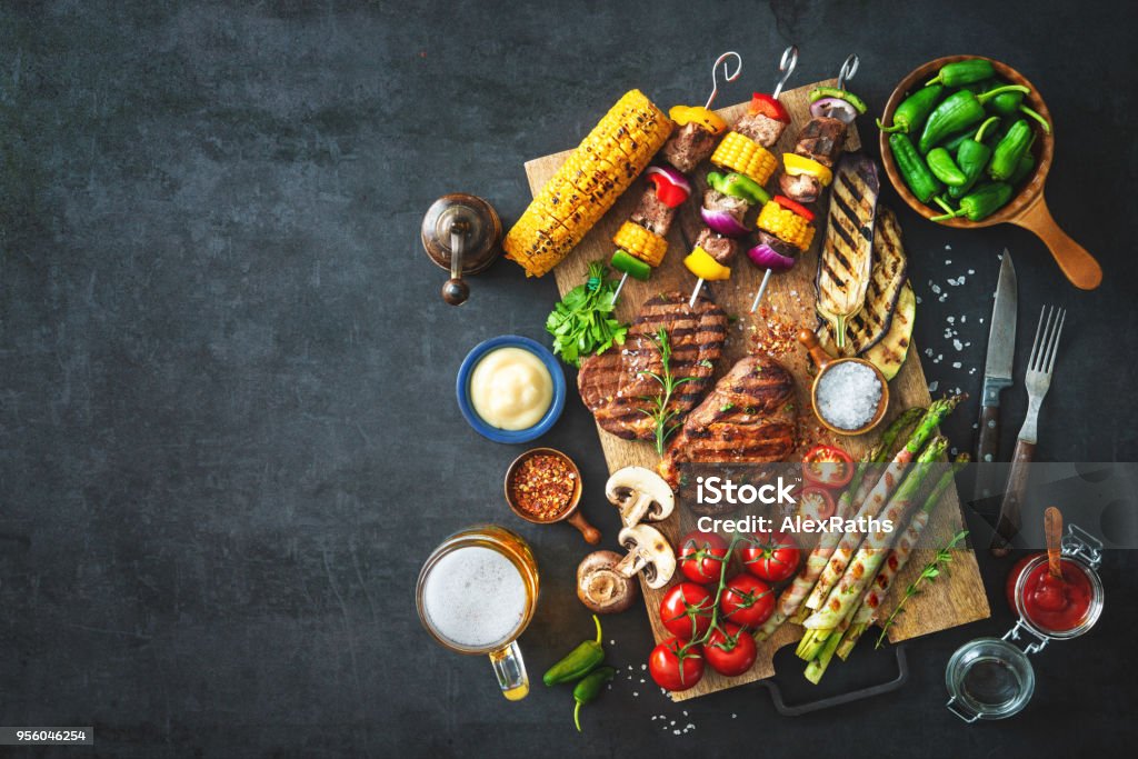 Grilled meat and vegetables on rustic stone plate Barbecue menu. Grilled meat and vegetables on rustic stone plate Barbecue Grill Stock Photo