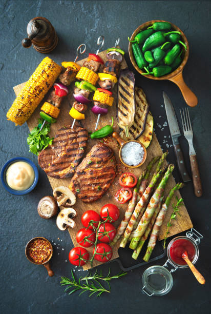 istock Grilled meat and vegetables on rustic stone plate 956046258