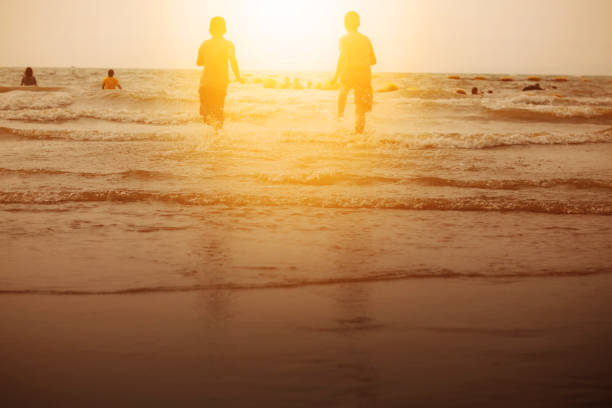 istock Children on beach at sunset. 956046330