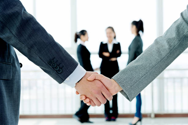 istock Businesspeople shaking hands closeup 956047936